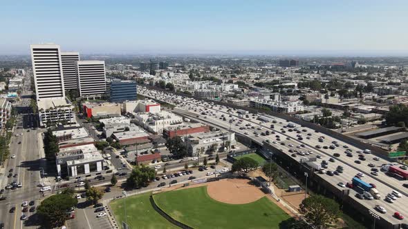 Aerial/Drone Slow Traffic on Los Angeles I405 near Century City toward Buildings