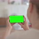 Rear View of Beautiful Woman Holding Smartphone with Green Screen