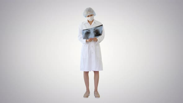 Woman Doctor in Mask Looking at Lung Xray on Gradient Background alt