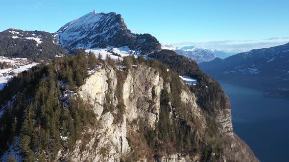 Aerial forward shot of snow covered observation platform on top of mountain against blue sky. Lake i alt