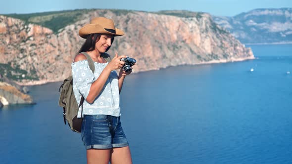 Smiling Backpacker Female Tourist Taking Photo of Beautiful Sea Landscape Using Camera alt
