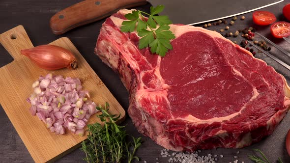 Raw T Bone steak on wooden board prepared to Grill on turntable
