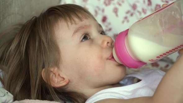 Little Baby Girl Sucks Bottle of Milk