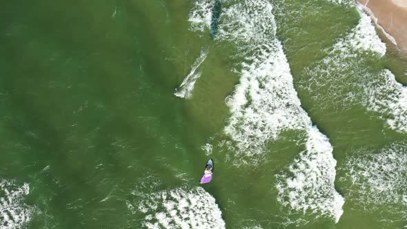 AERIAL: Top View Shot of One Surfer Riding Big Waves and Engaged in Extreme Sports