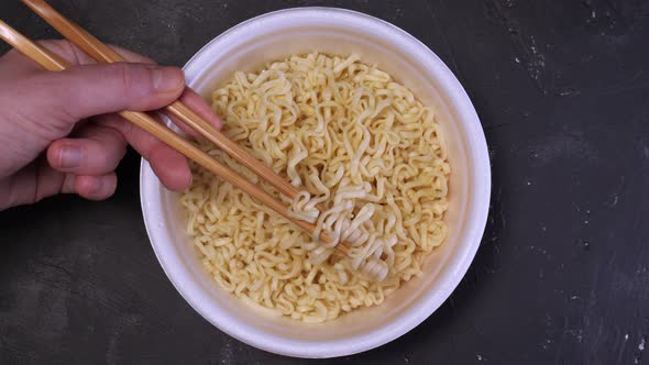 Girl's Hands Take the Noodles with Chopsticks and Think Up