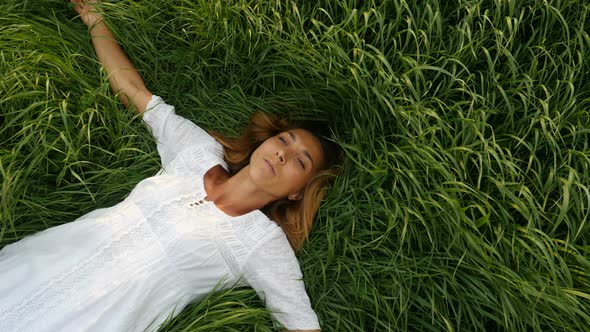 Beautiful Girl Lying on the Field. Young Cute Woman Dreams on the Nature
