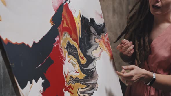 Woman Presenting Abstract Painting alt