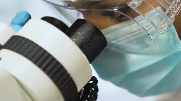 Mixed Race Female Scientist Carefully Doing Research Under Microscope, Closeup alt