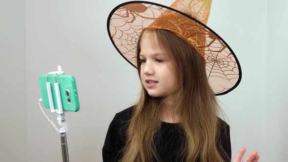 Little Girl Blogger Influencer Talking with Followers Live Streaming Wearing in Orange Hat Halloween alt