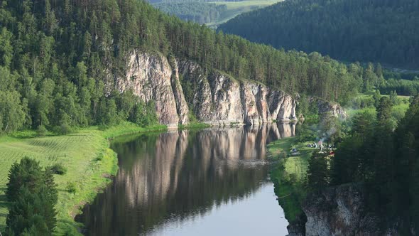 Time Lapse of People Swimming in River Agidel in Front of Scenic White Rock alt