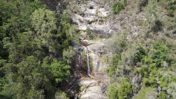 Aerial view over gerês national park, waterfall cascade, flowing down rock hill, Portugal