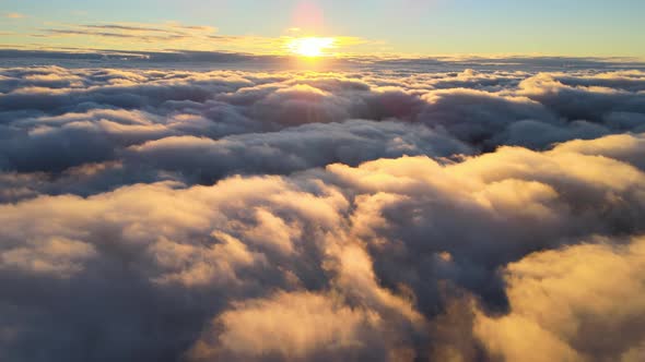 Aerial View From Above at High Altitude of Dense Puffy Cumulus Clouds Flying in Evening alt