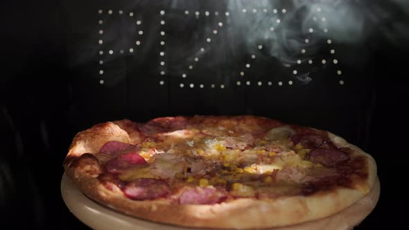 Delicious Fresh Italian Pizza On A Black Background With  The Effect Of Light Inscription Pizza