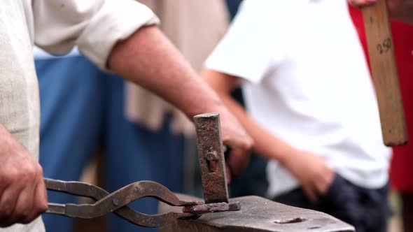 Close-up of forging a horseshoe. The blacksmith teaches