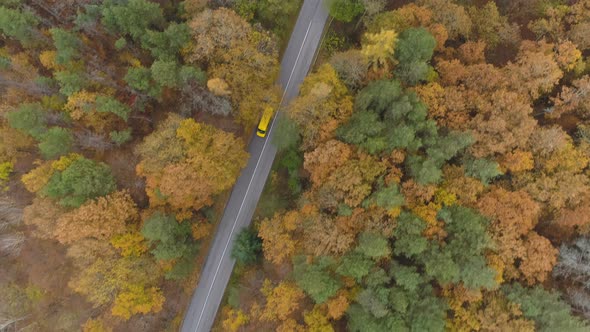 Drone Following Yellow Bus or Truck Speeding on Mountain Road in the Autumn alt