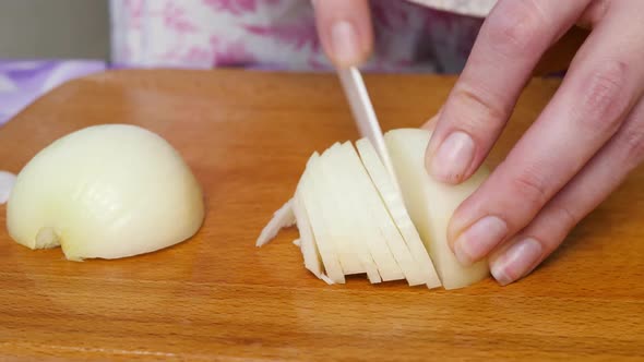 Woman Cutting White Onion on Wooden Board