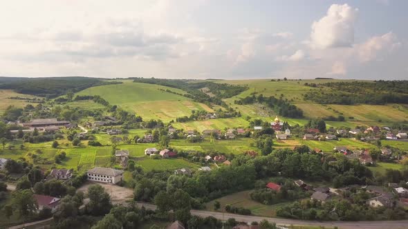 Aerial view of a small village between green summer hills in ukrainian Carpathian mountains  alt