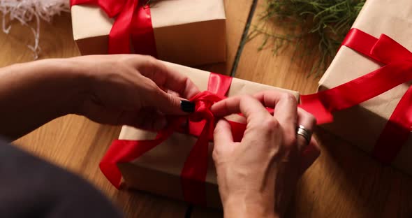 Hands of cropped unrecognisable woman packing Christmas present, Eco friendly packaging alt