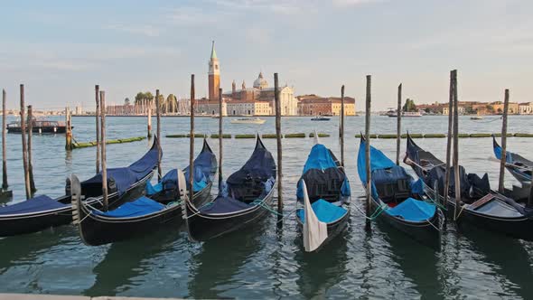 Docked Empty Gondolas on Wooden Mooring Piles Venice Italy alt