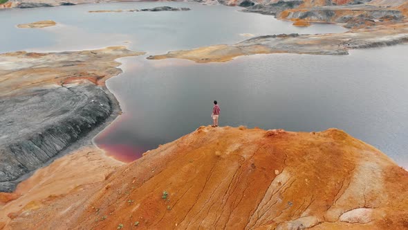 A Man Running on a Clay Mountain and Raising His Hands Up alt