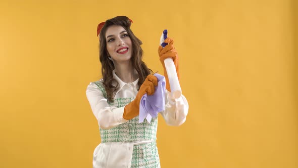 A Young Woman Washes an Invisible Window with Spray and a Rag