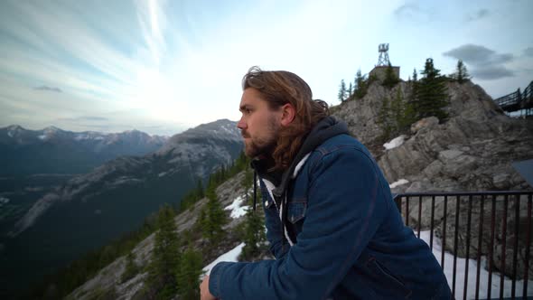 Smiling young man looking out over Jasper National, Alberta, Canada alt