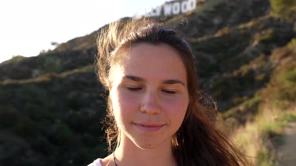 Beautiful Young Woman Portrait with Windy Hair Blinking Eyes Peace alt