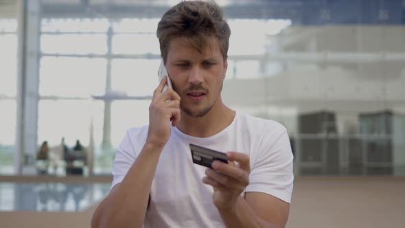 Smiling Man Dictating Card Number To Interlocutor Through Phone alt
