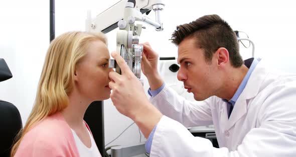 Optometrist examining female patient on phoropter alt