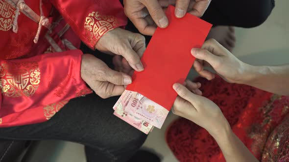 Hands Of Asian Family Giving Red Envelope To Parents On Chinese New Year