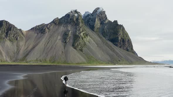 Drone Of Man On Black Beach Under Vestrahorn Mountain alt