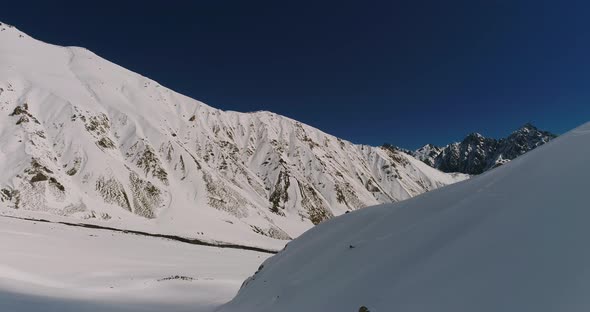 Snowboarder Carves His Board Through Snow Down Cool Mountain Landscape in Chile Andes Range alt