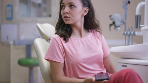 Young Caucasian Woman Sitting in Dentist Chair Standing Up Walking Away in Slow Motion Leaving alt
