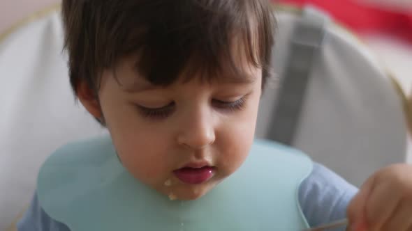 Child Eats Soup with an Iron Spoon alt