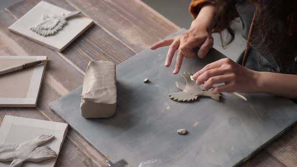 Top View of Potter Woman Hands Working on Details of a Clay Handcraft Bird alt