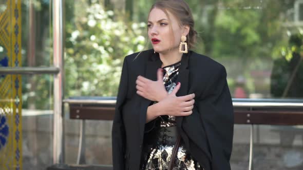 Medium Shot Portrait Young Tired Sad Woman in Party Dress and Jacket Standing on Bus Stop Waiting alt