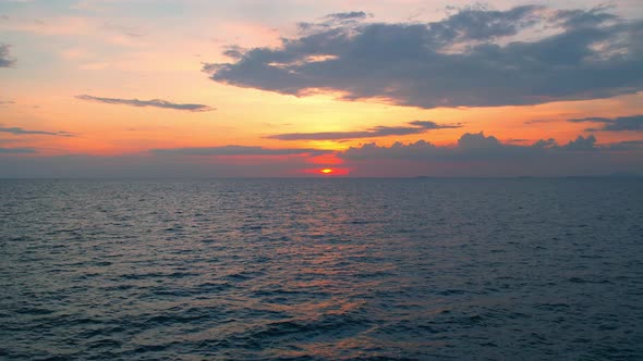 4K drone flying over the sea, sunset on the horizon. alt