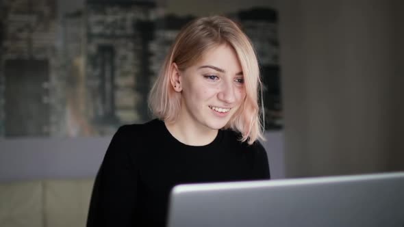 Young smiling woman face looking at laptop, female freelancer at home