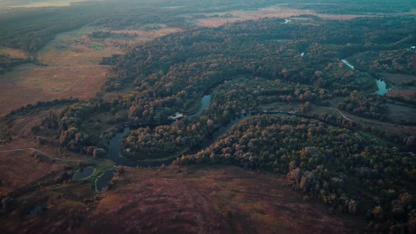 Waving watercourse of a river in the countryside lit by first sun rays in the morning