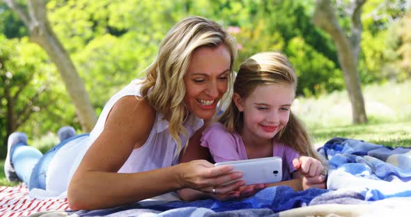 Mother and daughter taking selfie with mobile phone in park 4k alt