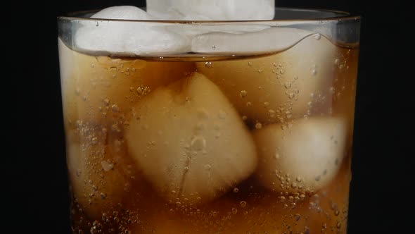 cola with ice cubes close up