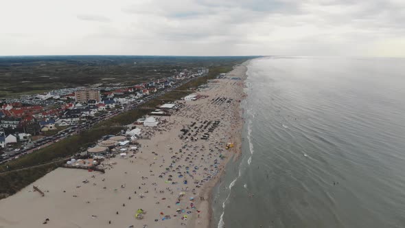 Drone footage of a crowded beach along the coast of Zandoort, Netherlands. alt