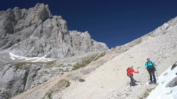 Couple Hiking Over Scree High up in Mountains