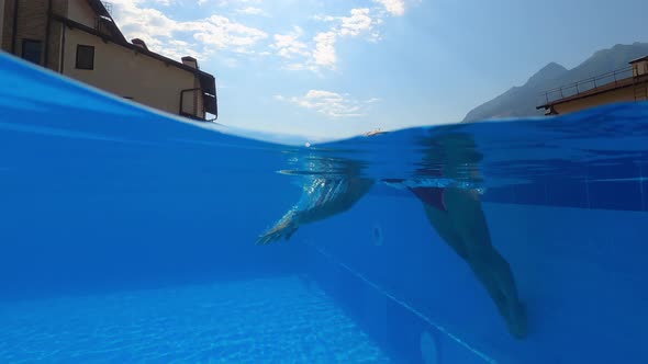 Sexy Lady is Swimming in Outdoor Pool of Small Hotel Plunging and Floating Underwater alt