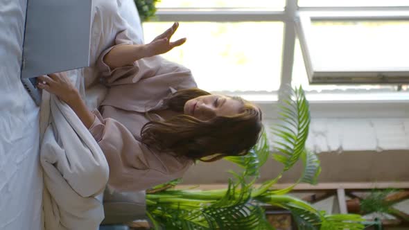 Vertical Video of a Woman in Front of a Laptop Monitor in Bed alt