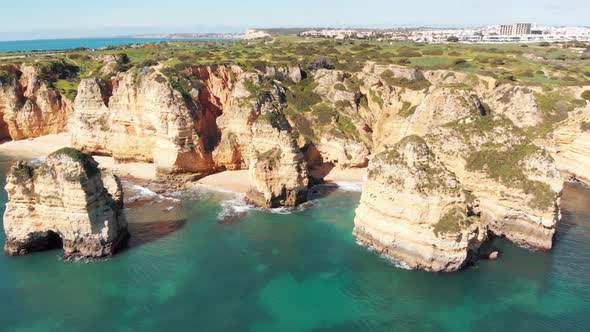 Intimate sandy coves surrounded by towering eroded cliffs in Lagos, Algarve, Portugal alt