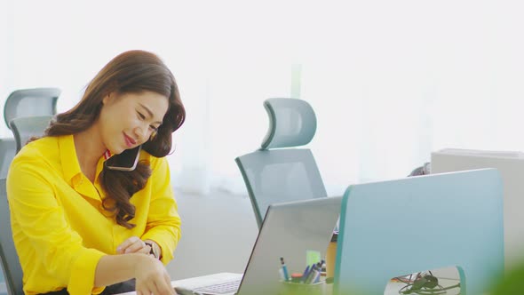 Asian Business woman writing down requirement to paper and talking with customer alt