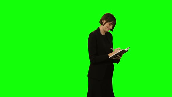 Beautiful businesswoman writing in diary alt