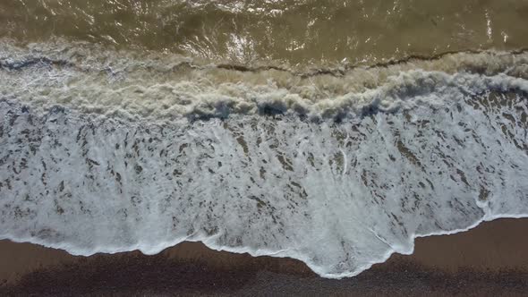 Top-down view of the water surface. View of the storm in the dirty sea from a height.