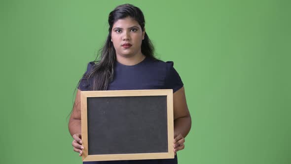 Young Overweight Beautiful Indian Businesswoman Against Green Background alt